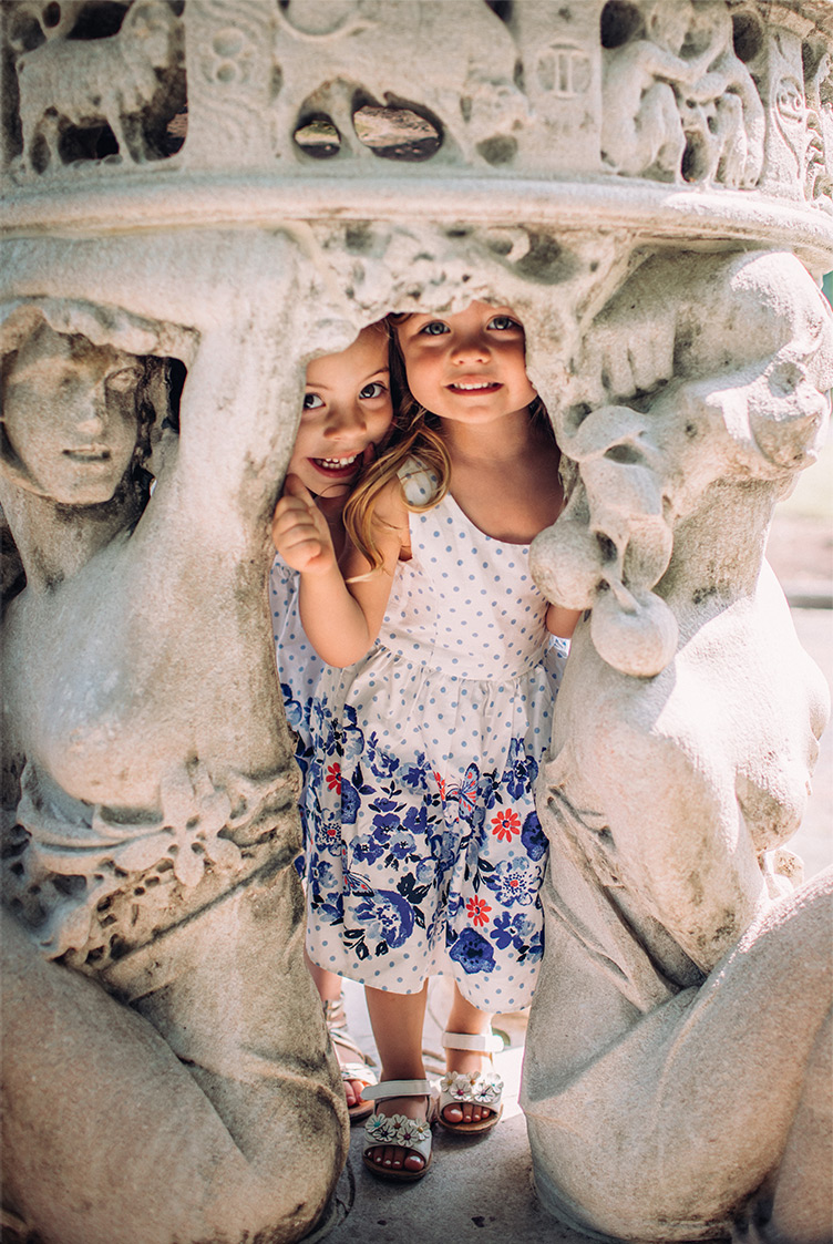 two little girls hiding in a statue photographed by Philadelphia family photographer