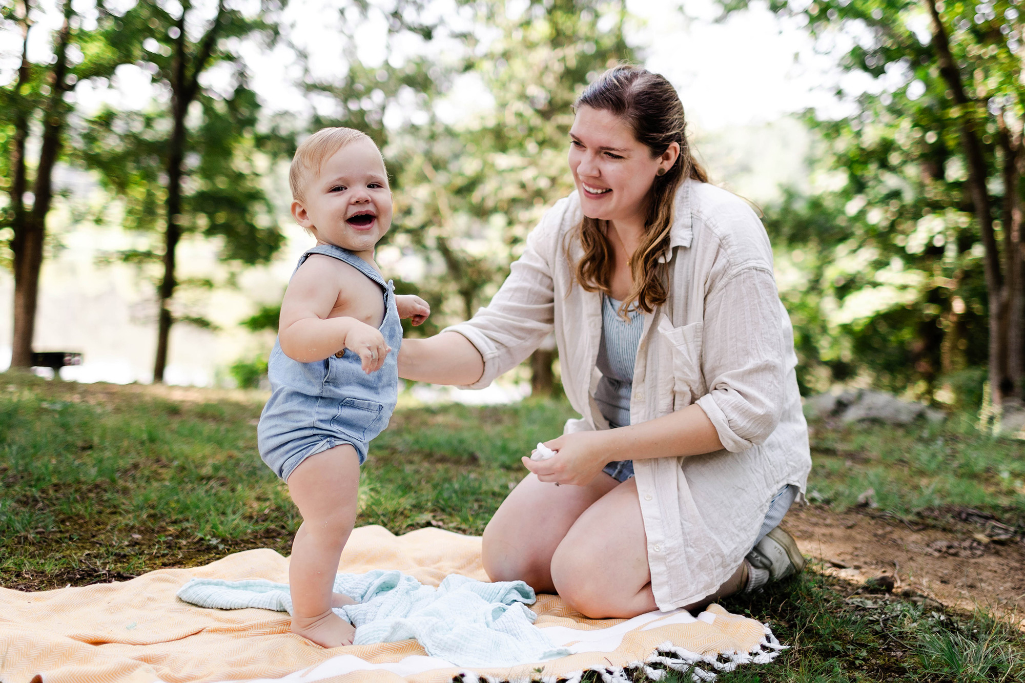 baby standing while mom holds him