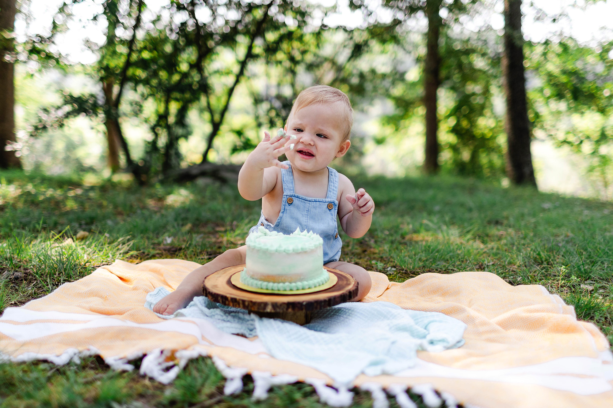 baby looking at icing on his hand