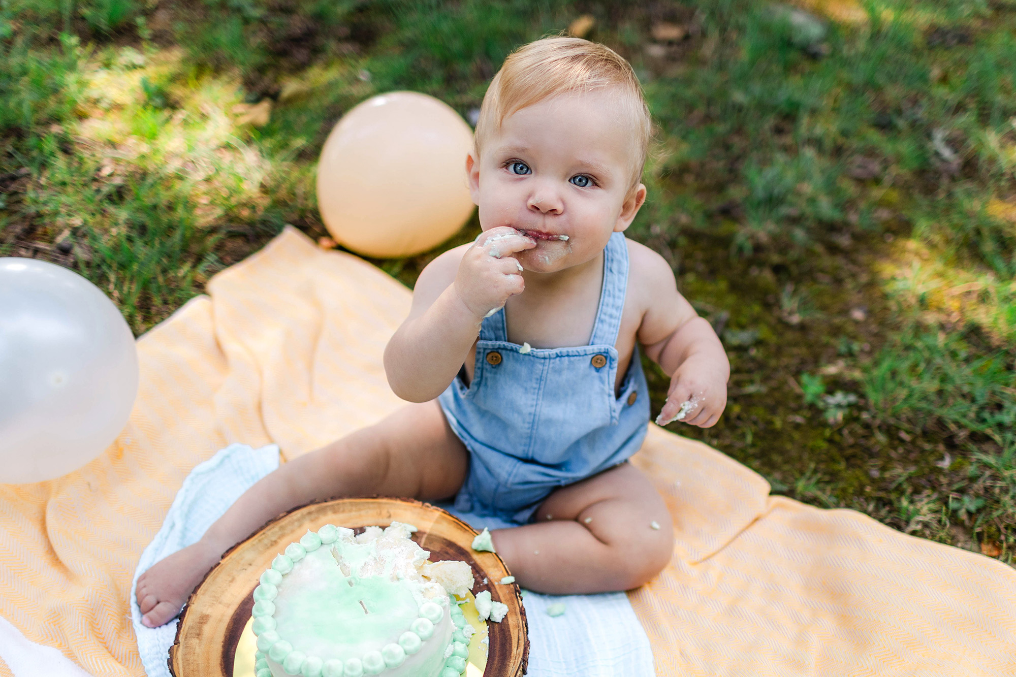 baby looking at camera, tasting his cake