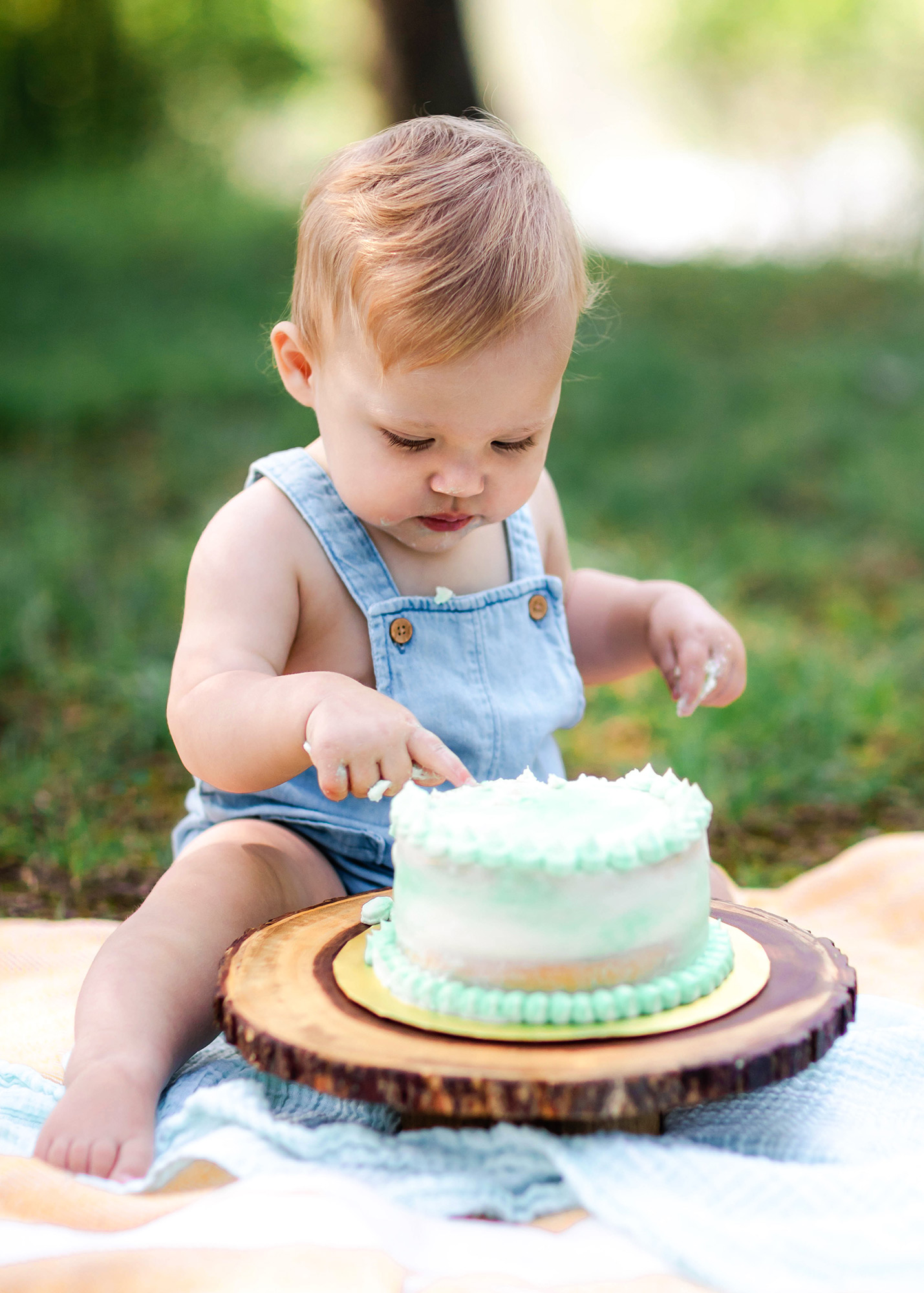 baby poking his finger into his cake