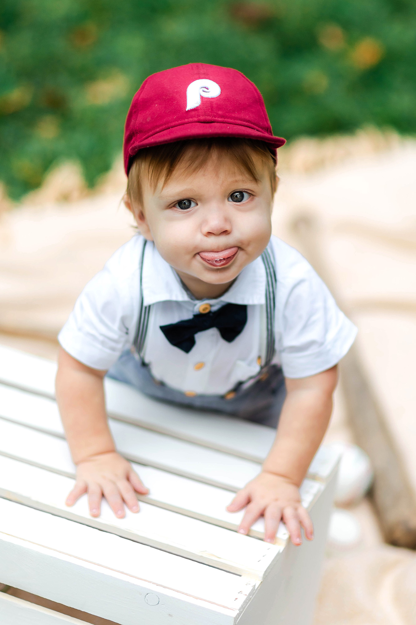 baby wearing Phillies hat sticking out his tongue