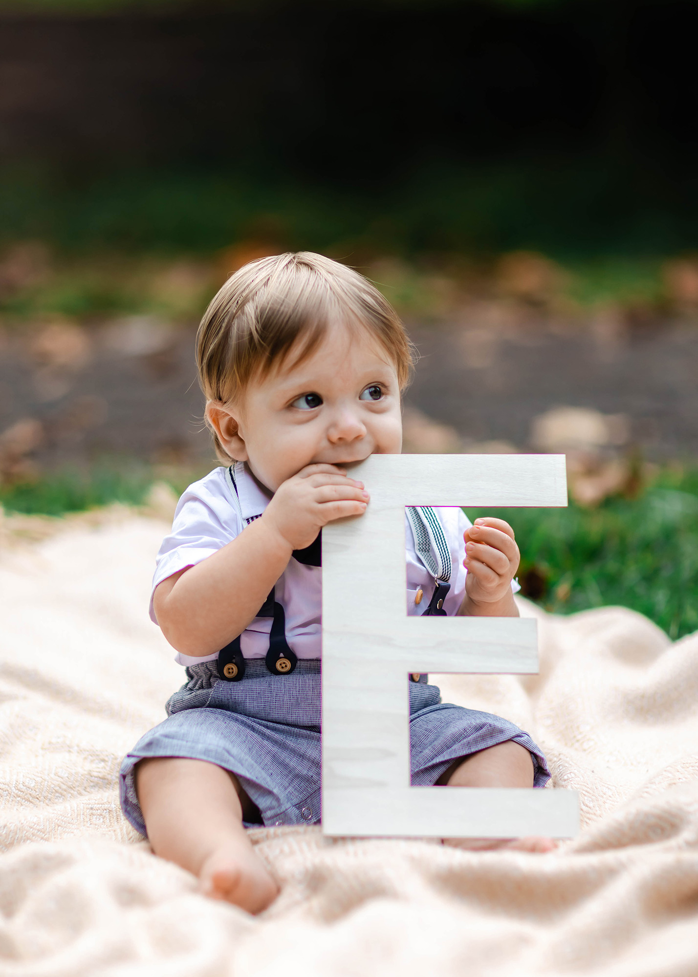 baby boy holding wood letter E