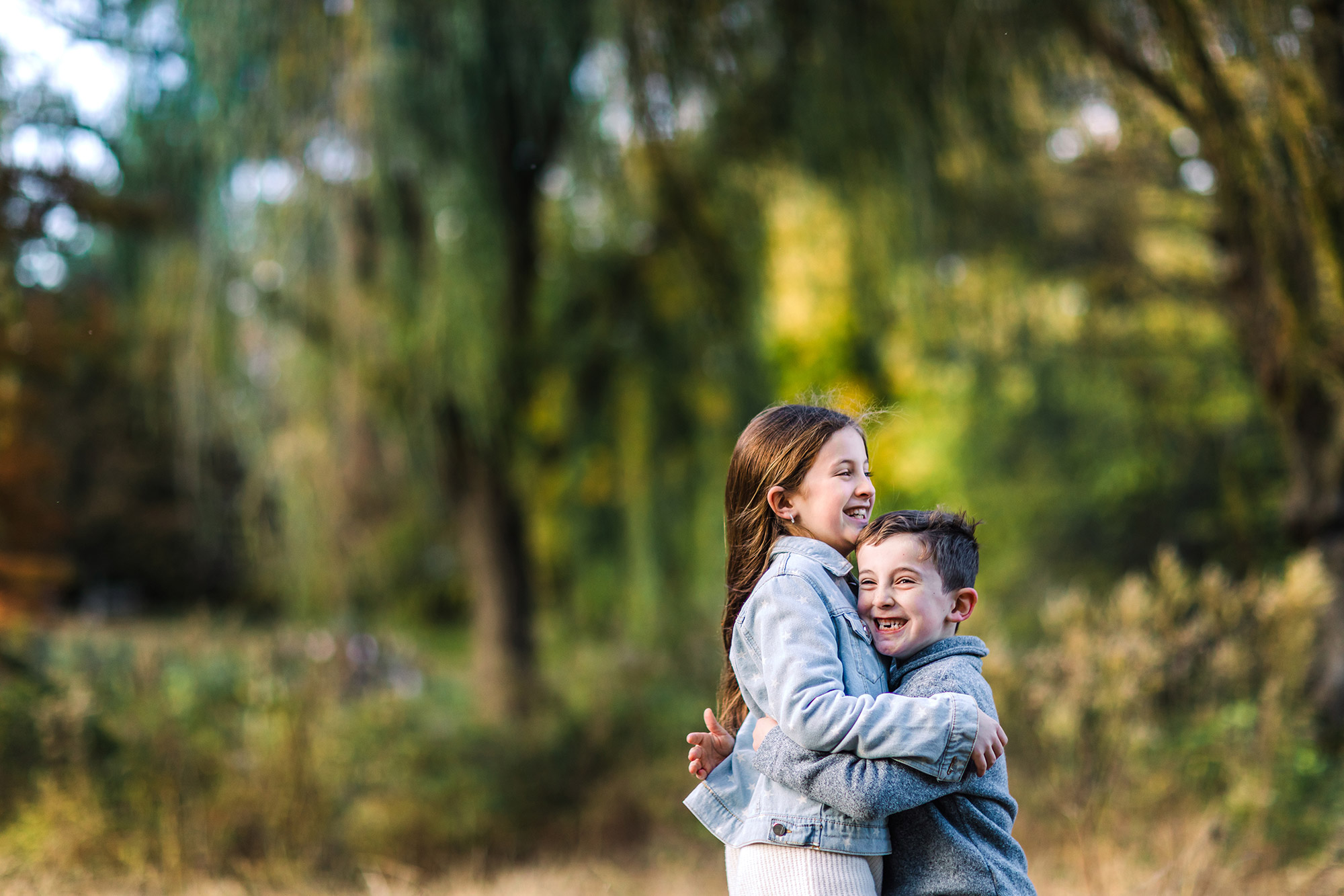 brother and sister hugging, captured by Evergreen Story Photo