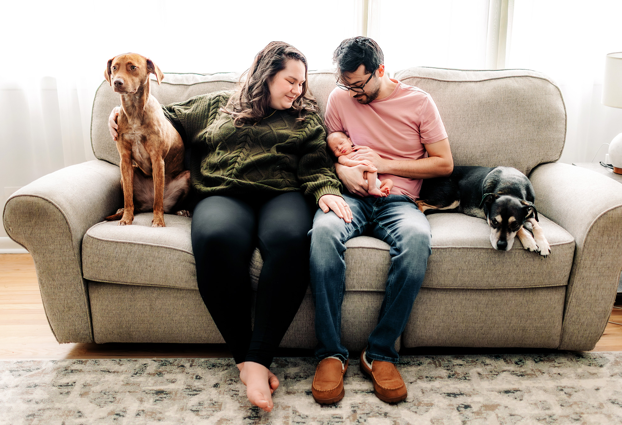 Newborn surrounded by mom, dad and two dogs