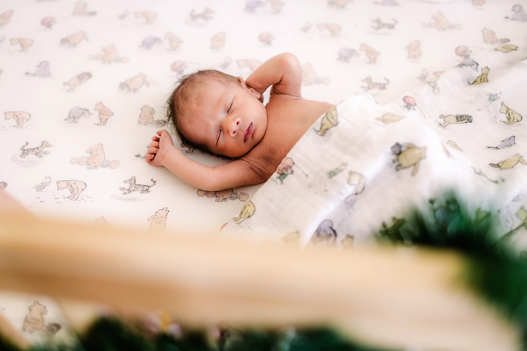 Newborn in Winny the Pooh crib