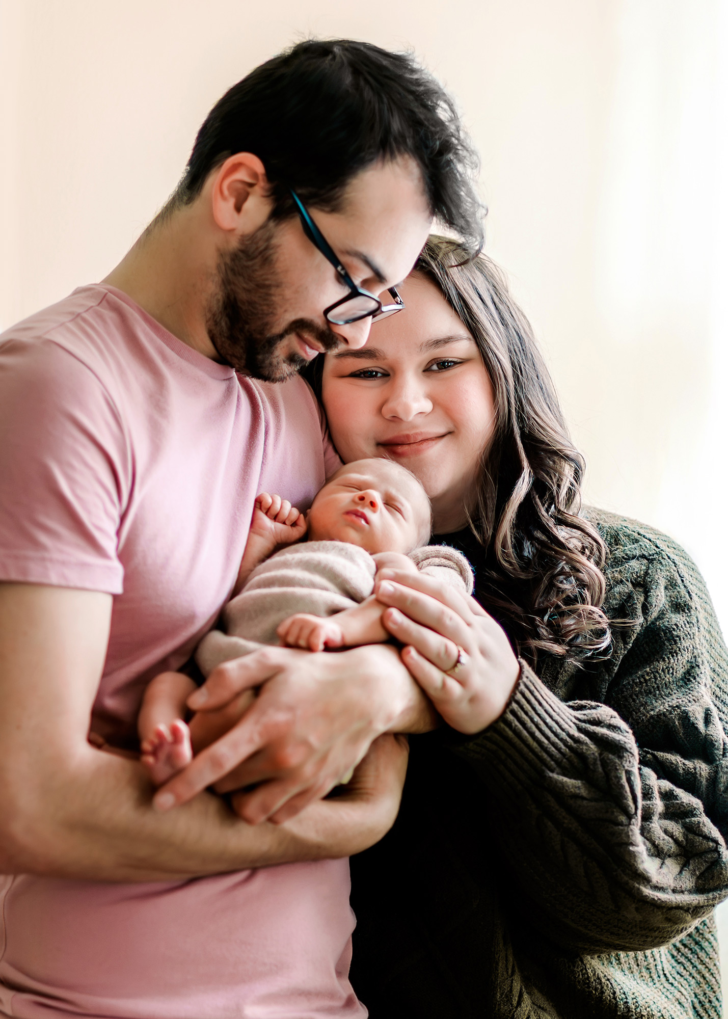Dad holding newborn while mom smiles