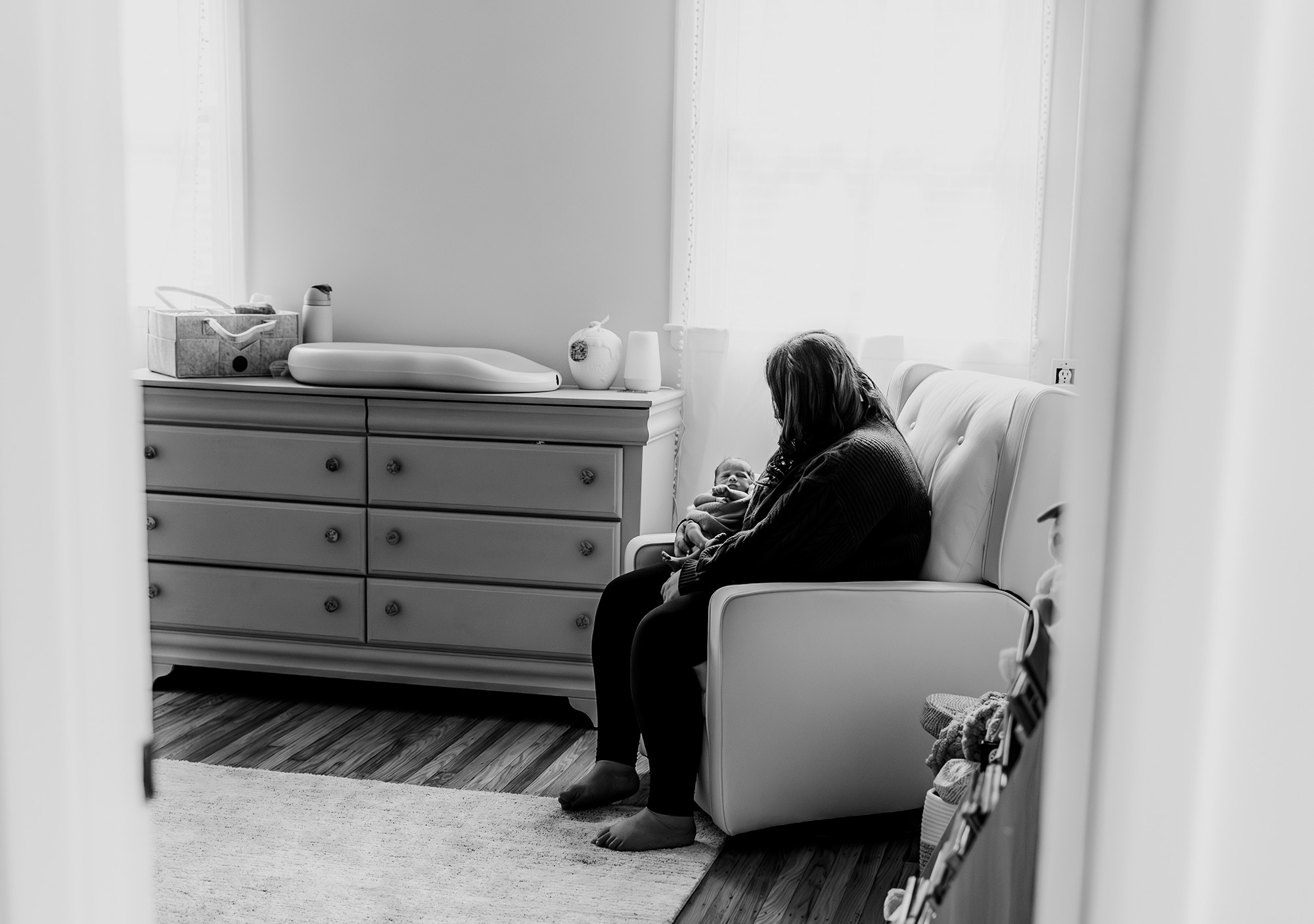 Looking into the nursery where mom is sitting and holding her baby
