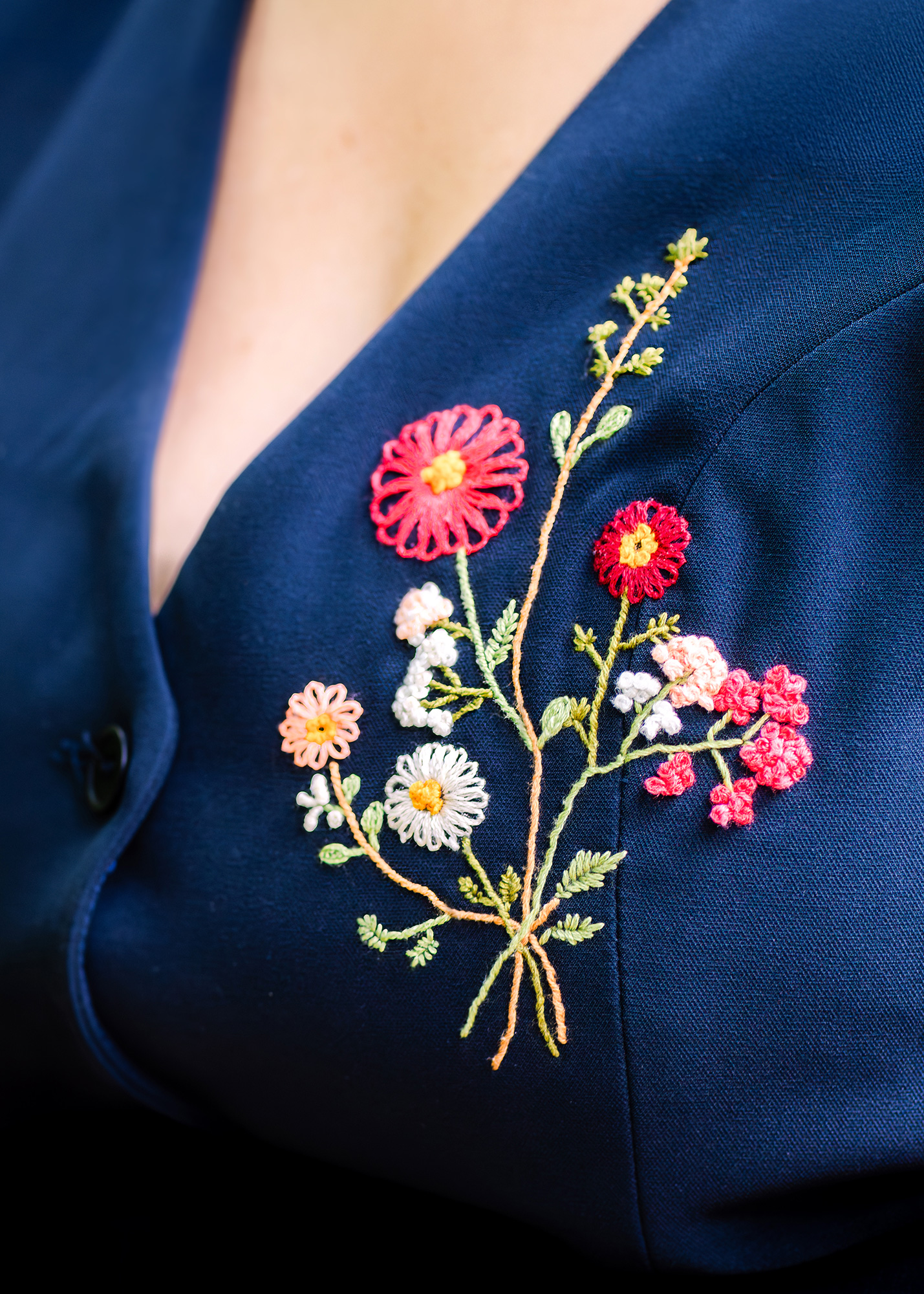 Closeup of wildflower embroidery on bride's vest