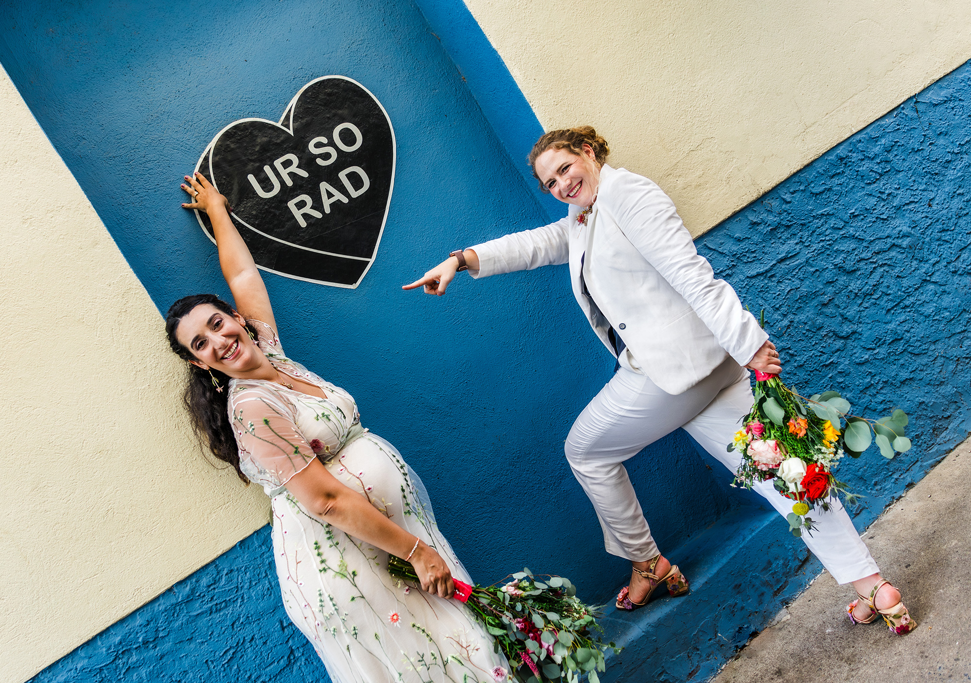 Two brides post in front of Amberella heart in manayunk