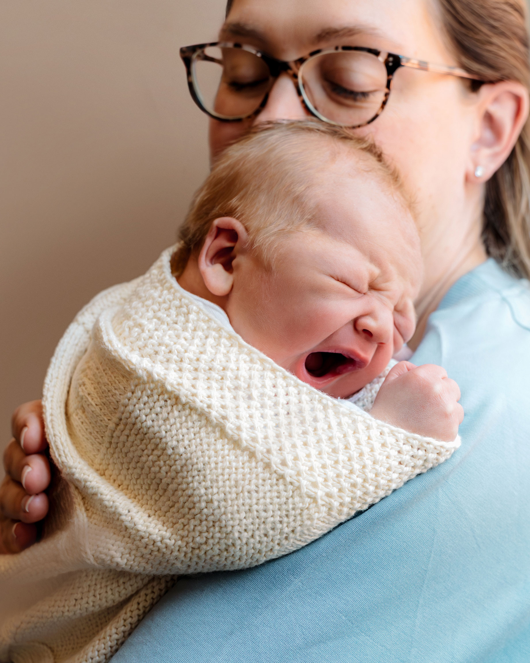 newborn baby yawning on mom's shoulder