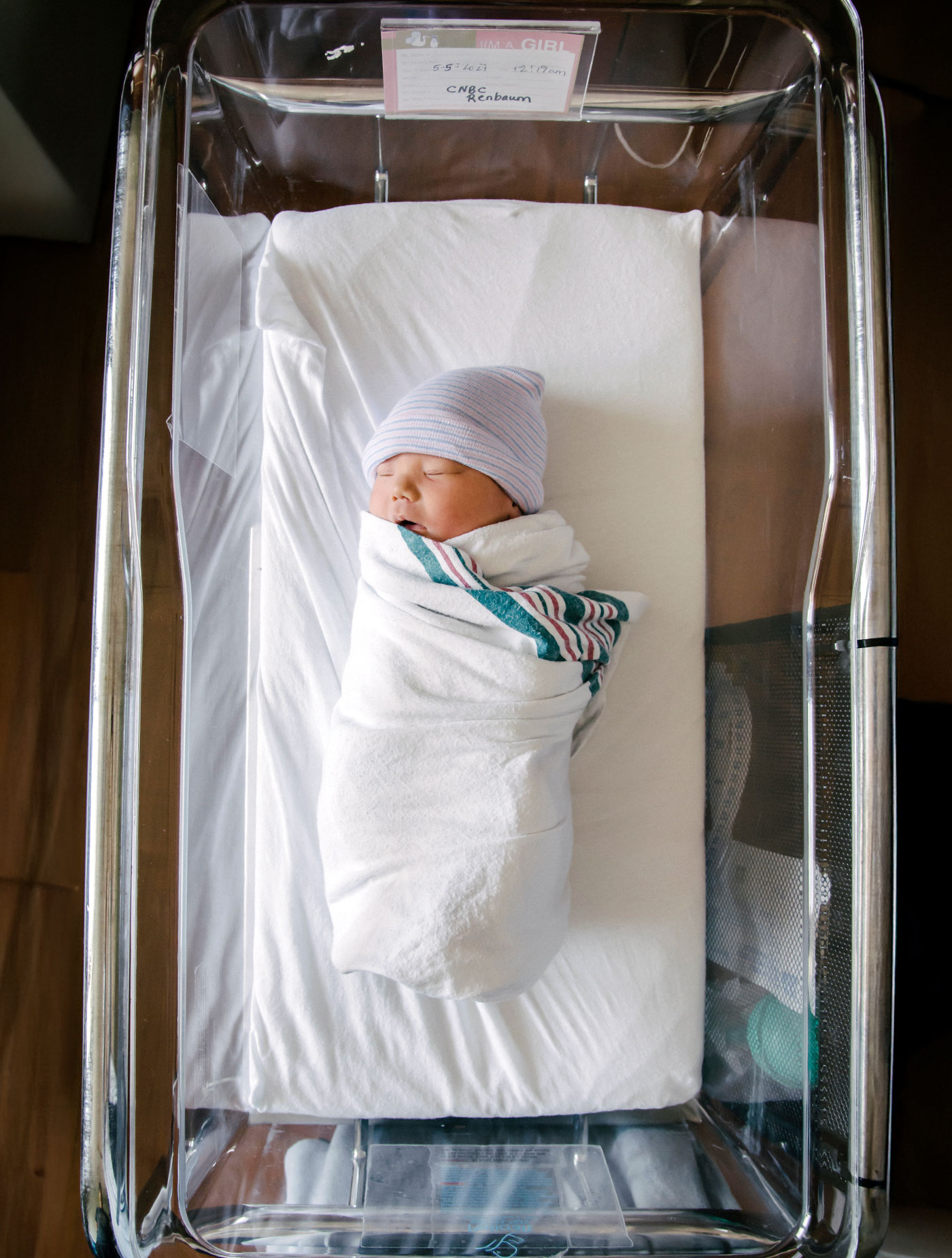 Newborn baby sleeping in a hospital bassinet, a photo by Evergreen Story