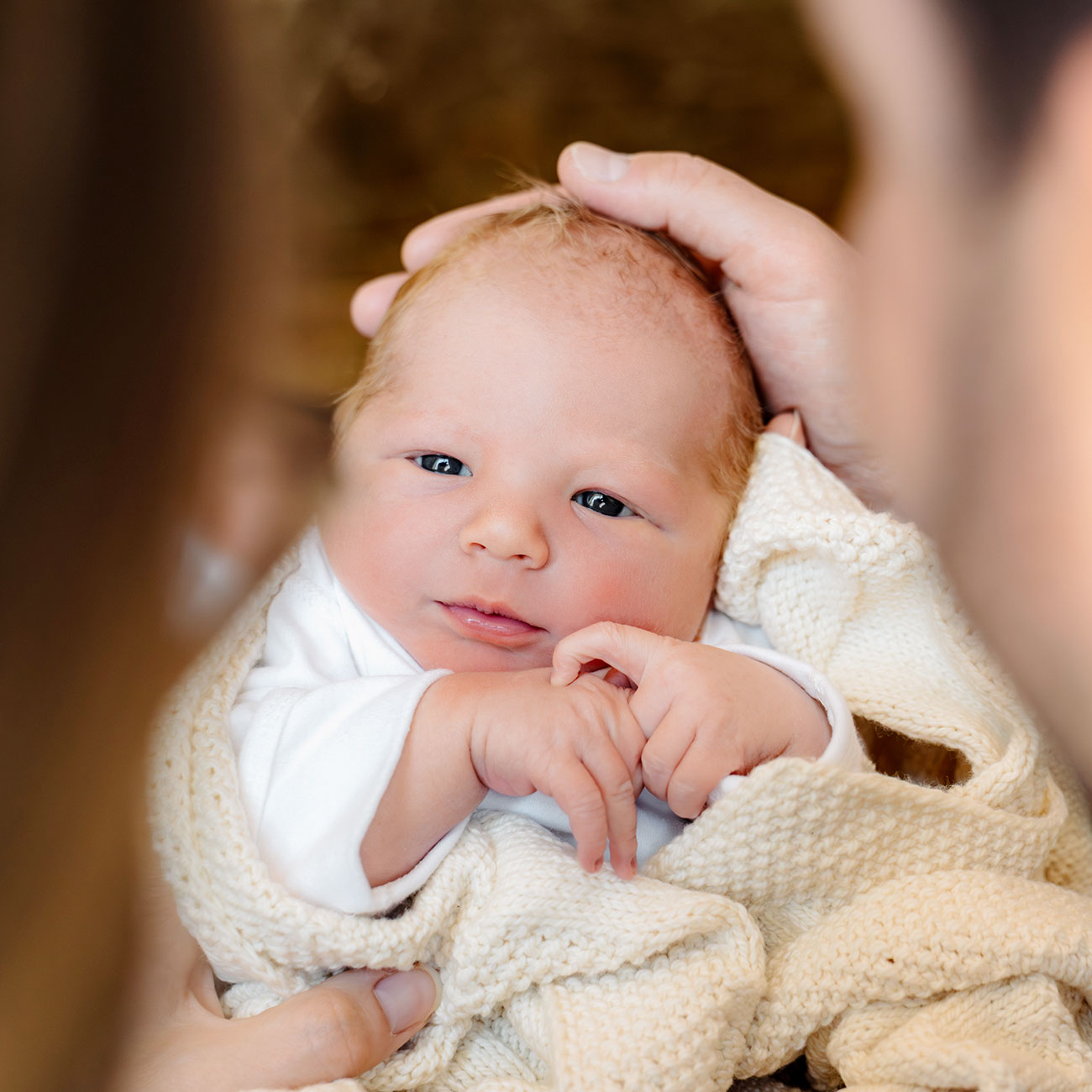 dad cradling newborn baby's head