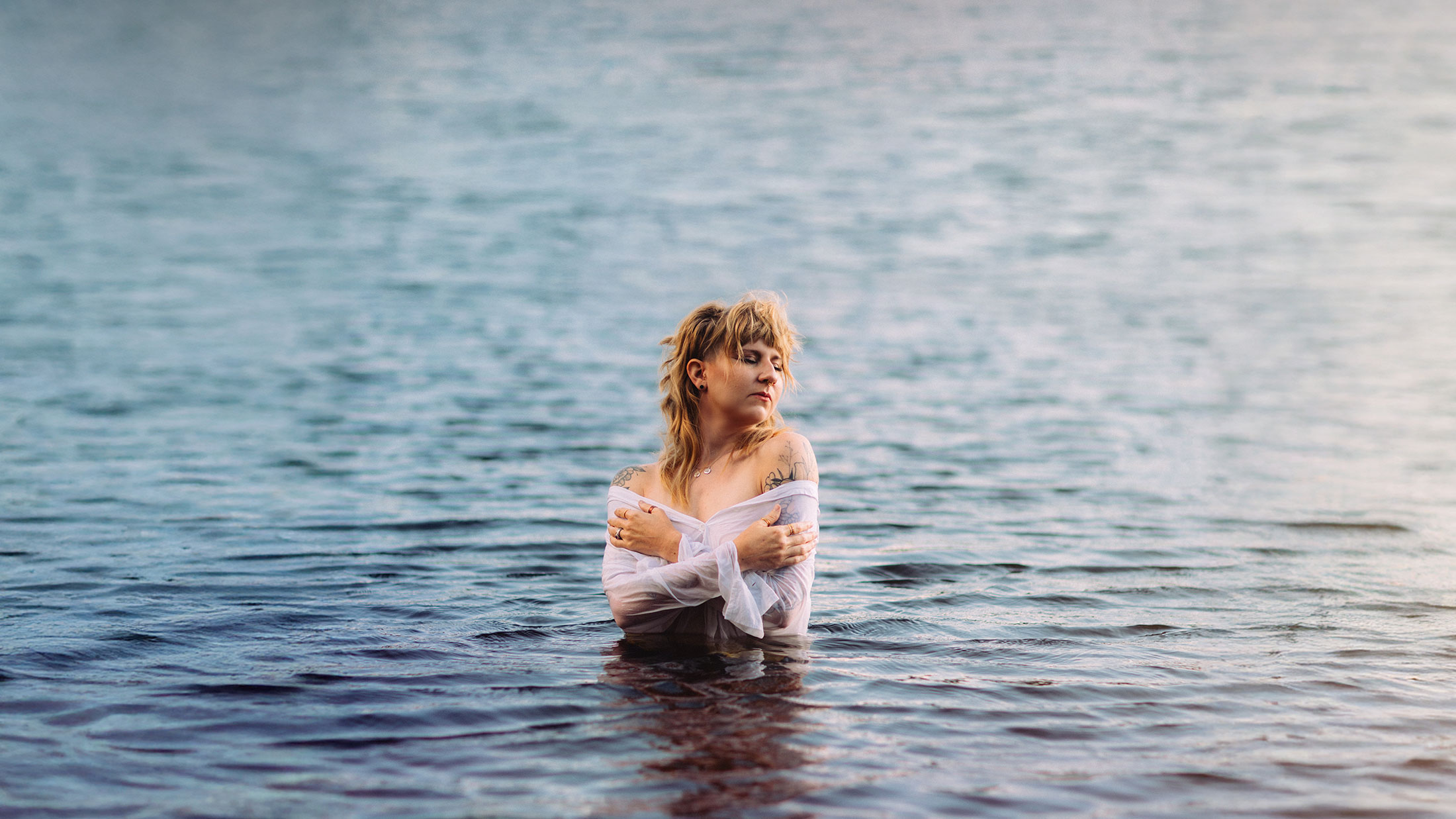 woman in the middle of a lake, surrounded by water. A photo by Evergreen Story