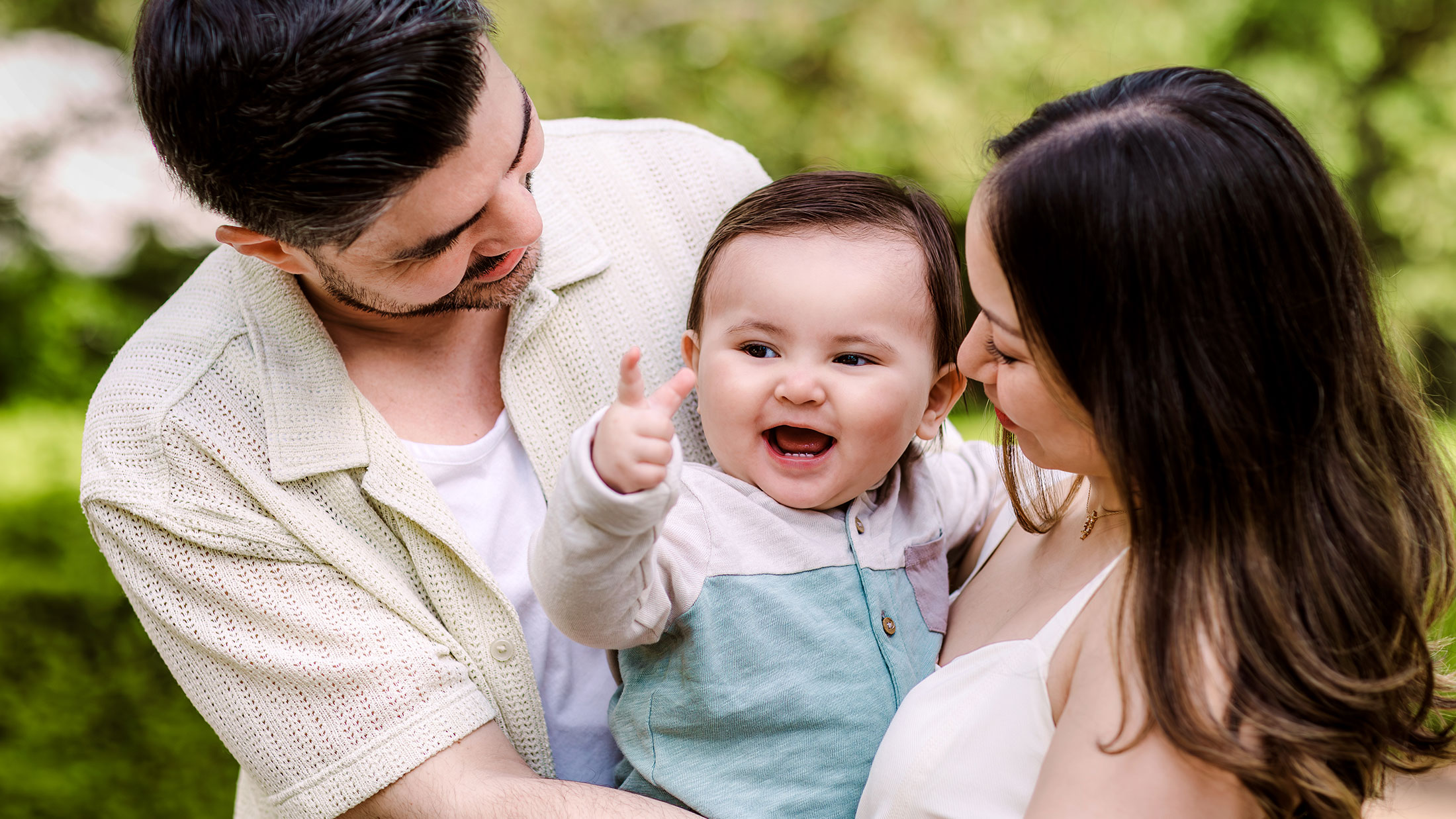 Mom and dad holding a smiling baby between them