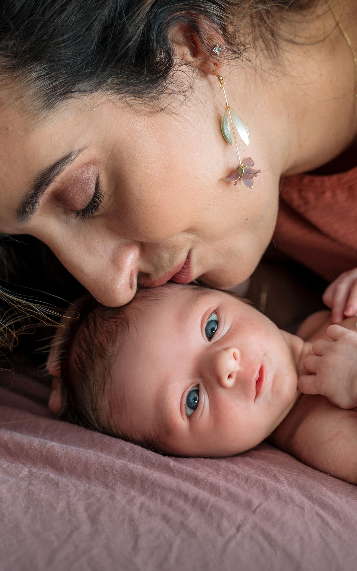 Mother kissing her newborn daughter